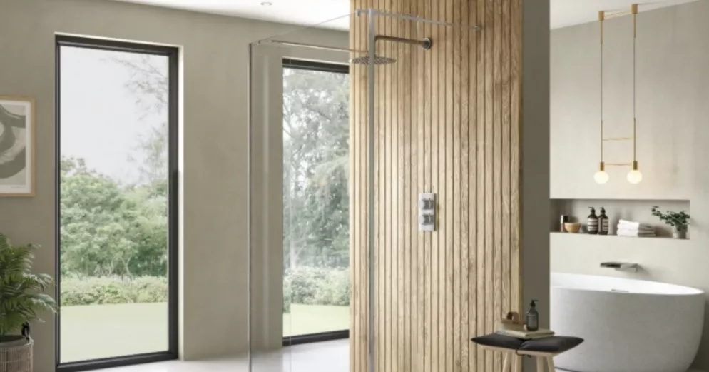 A bath inside an open-plan bathroom with a shower beside it.